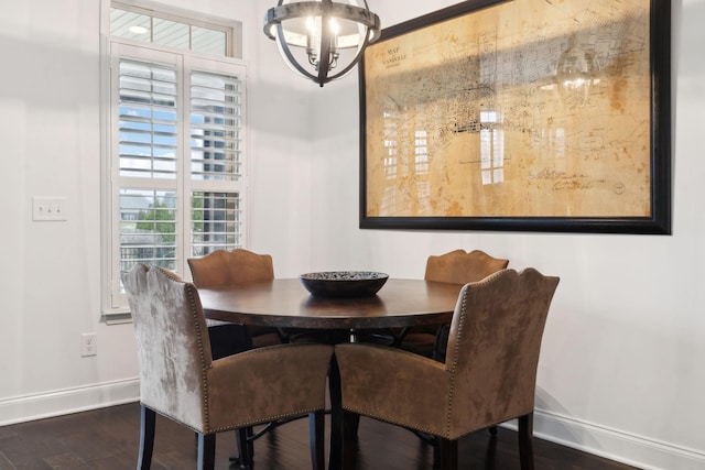 dining space with dark hardwood / wood-style flooring and a notable chandelier