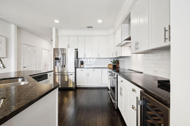 kitchen featuring dark stone countertops, stainless steel appliances, beverage cooler, and white cabinets