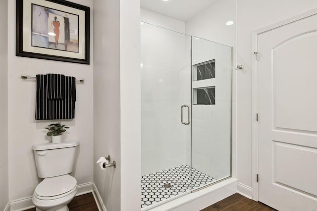 bathroom featuring an enclosed shower, hardwood / wood-style flooring, and toilet