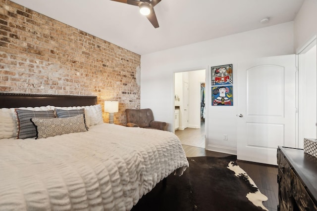 bedroom featuring ceiling fan, brick wall, and dark hardwood / wood-style flooring