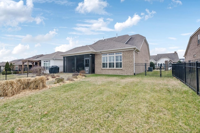 rear view of house with a yard and a sunroom