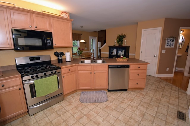 kitchen with stainless steel appliances, sink, pendant lighting, and light brown cabinetry