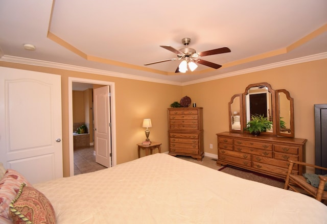 bedroom featuring crown molding, ceiling fan, ensuite bathroom, and a tray ceiling