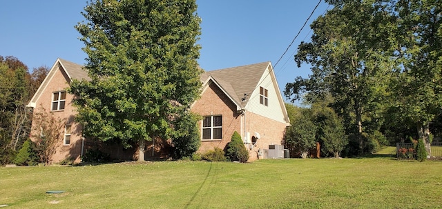 view of side of home featuring central AC and a lawn