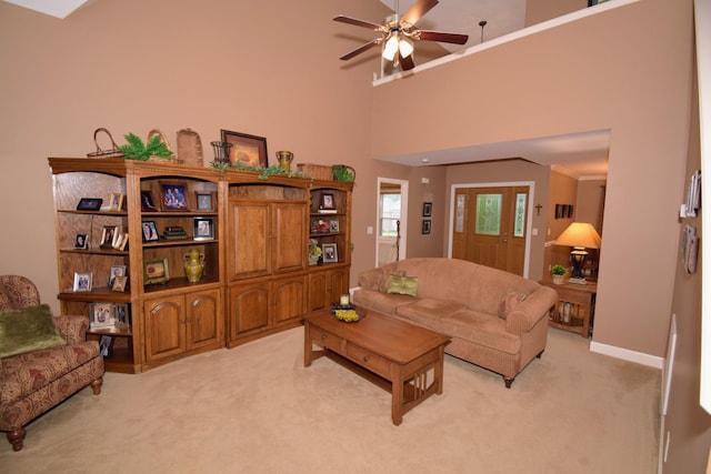 living room with ceiling fan, light colored carpet, and a high ceiling