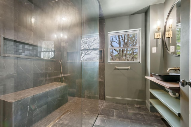 bathroom featuring tiled shower and sink