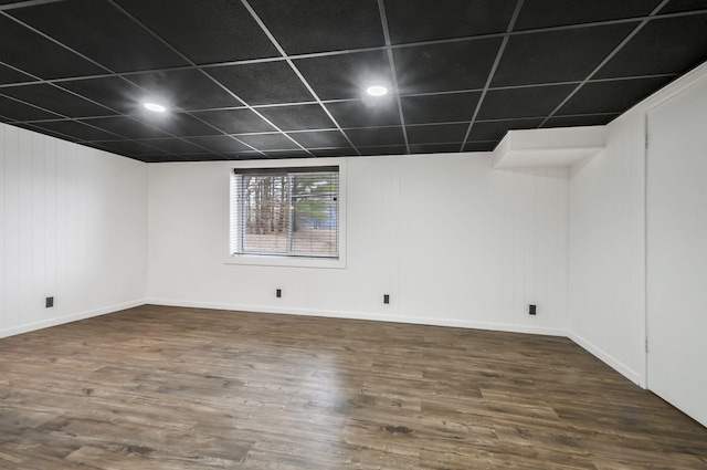 empty room with a paneled ceiling and dark hardwood / wood-style floors