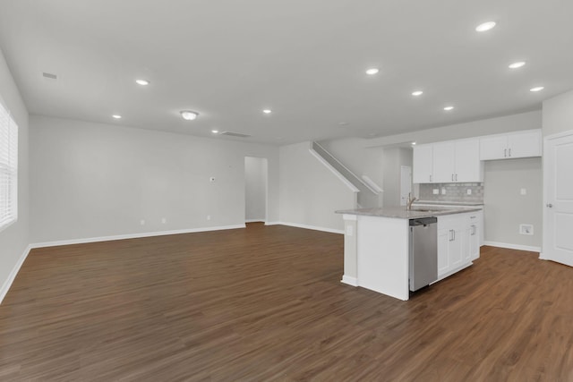 kitchen with dark hardwood / wood-style floors, dishwasher, white cabinets, decorative backsplash, and a center island with sink