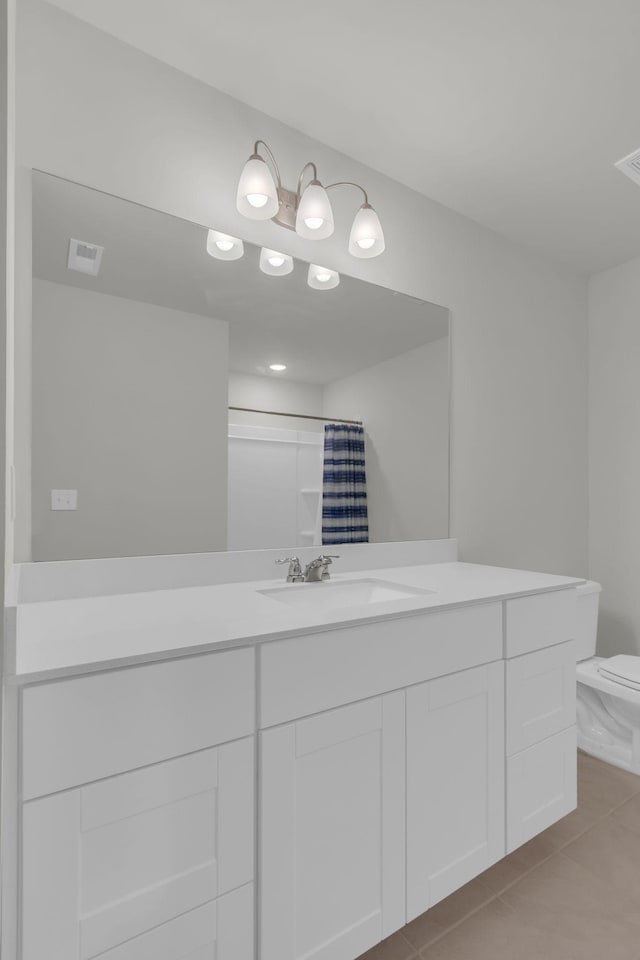 bathroom featuring vanity, a shower with shower curtain, tile patterned floors, and toilet