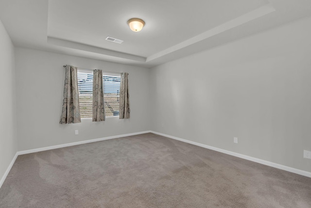 unfurnished room featuring carpet flooring and a tray ceiling