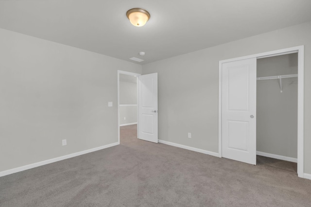 unfurnished bedroom with light colored carpet and a closet