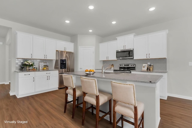 3280 Holiday Ln, Columbia, TN 38401 - kitchen with stainless steel appliances, backsplash, dark wood-style flooring, a kitchen bar, and an island with sink