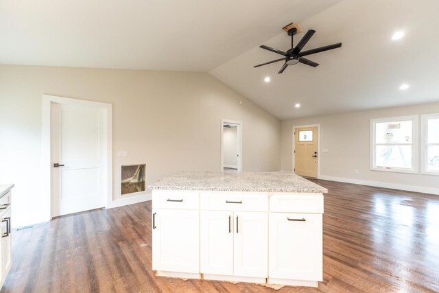 kitchen featuring a kitchen island, white cabinetry, lofted ceiling, dark hardwood / wood-style flooring, and light stone counters