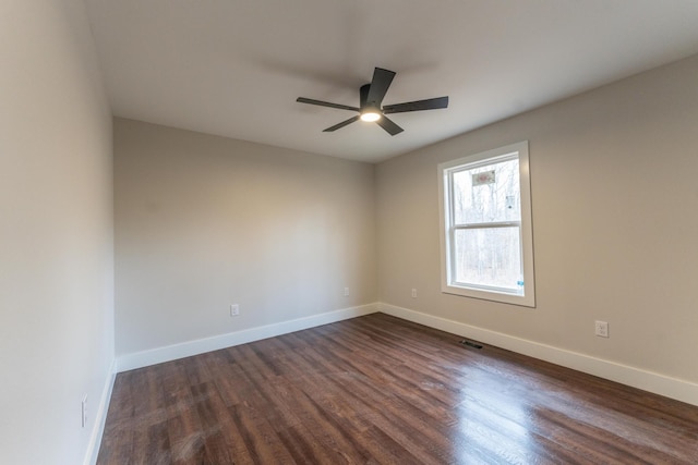 spare room with dark wood-type flooring and ceiling fan