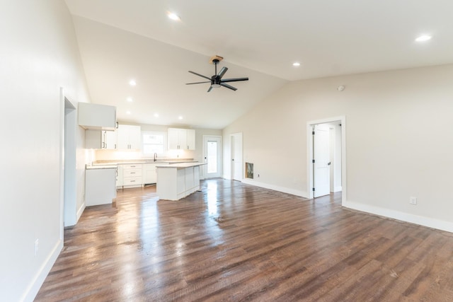 unfurnished living room with high vaulted ceiling, dark hardwood / wood-style floors, and ceiling fan