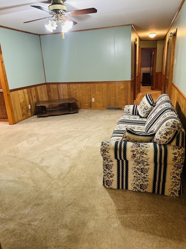 living room with light carpet, crown molding, and wooden walls