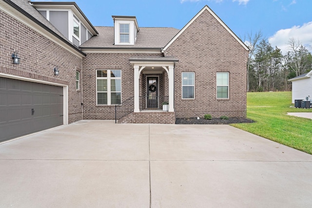 view of front facade with a garage, a front lawn, and central air condition unit