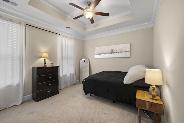 bedroom featuring multiple windows, a tray ceiling, and light carpet