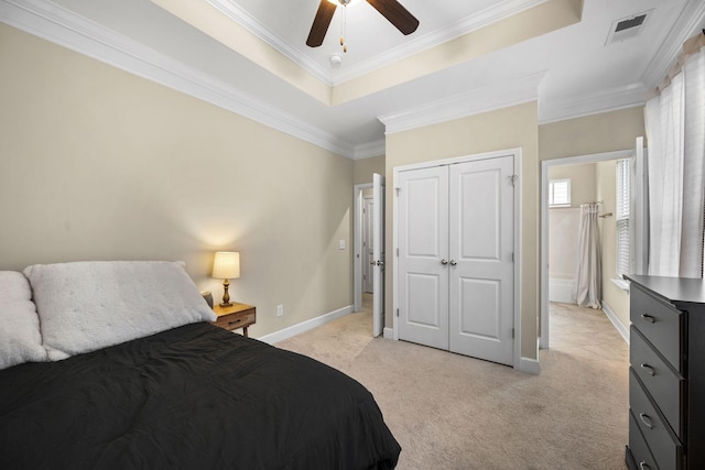 carpeted bedroom featuring a raised ceiling, crown molding, ceiling fan, and a closet