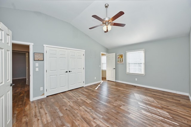 unfurnished bedroom featuring hardwood / wood-style floors, vaulted ceiling, a closet, and ceiling fan