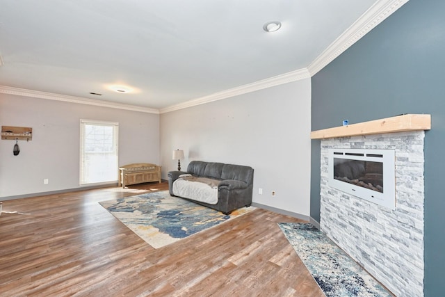 living area with crown molding, wood-type flooring, and a fireplace