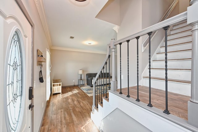 foyer with wood-type flooring and ornamental molding