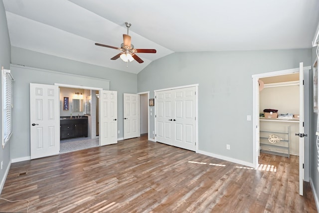 unfurnished bedroom with vaulted ceiling, ensuite bathroom, ceiling fan, and dark hardwood / wood-style flooring