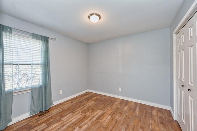 unfurnished bedroom with hardwood / wood-style floors and a closet