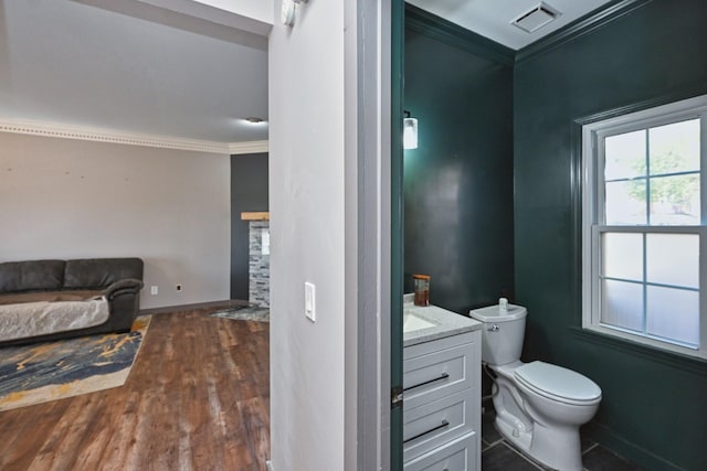 bathroom with crown molding, wood-type flooring, vanity, and toilet