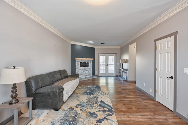 living room with french doors, a fireplace, crown molding, and hardwood / wood-style floors