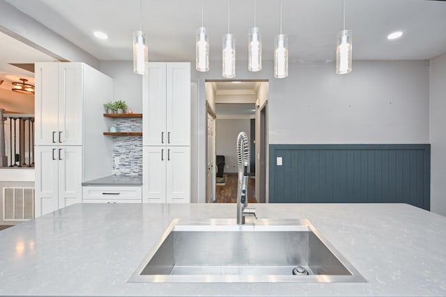 kitchen with pendant lighting, sink, tasteful backsplash, and white cabinets