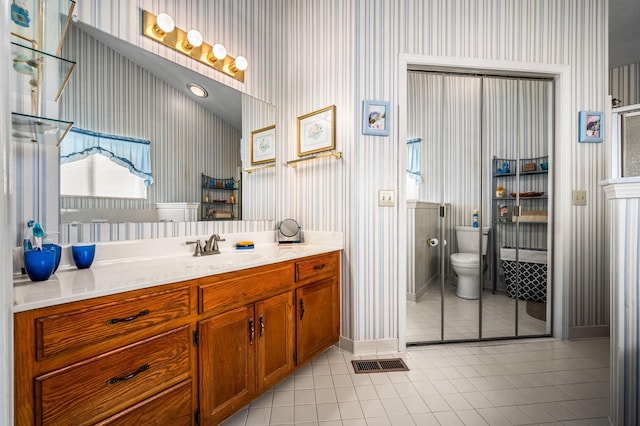 bathroom featuring vanity, toilet, and tile patterned flooring