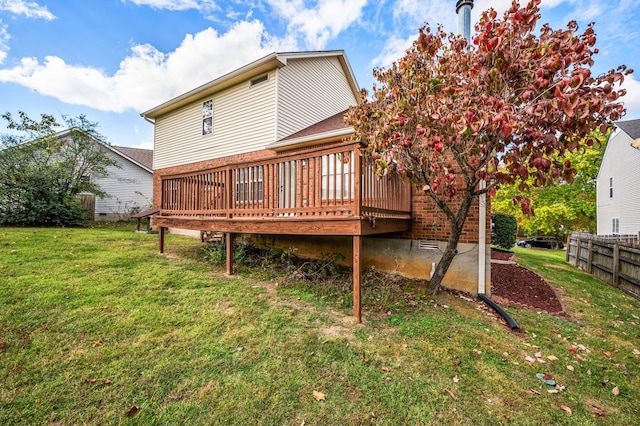 back of house featuring a wooden deck and a yard