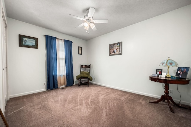 living area featuring ceiling fan, a textured ceiling, and carpet