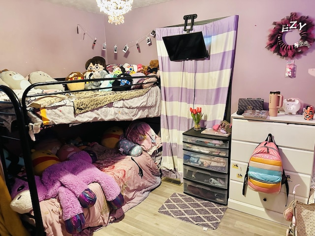 bedroom with a notable chandelier and light hardwood / wood-style flooring