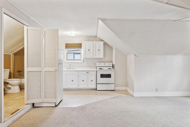 kitchen with white appliances, lofted ceiling, sink, and white cabinets