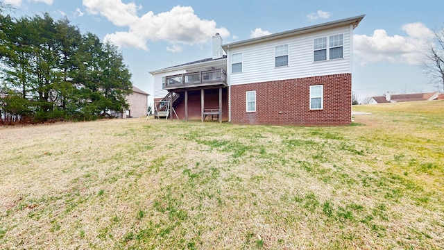 back of property with a deck and a lawn