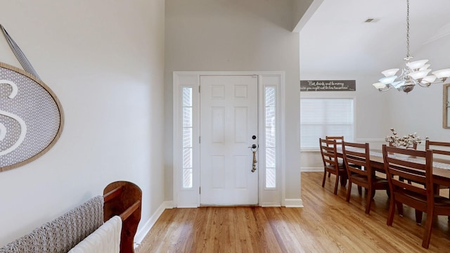 entryway with an inviting chandelier and light hardwood / wood-style flooring