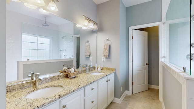 bathroom featuring tile patterned floors, vanity, and a tile shower