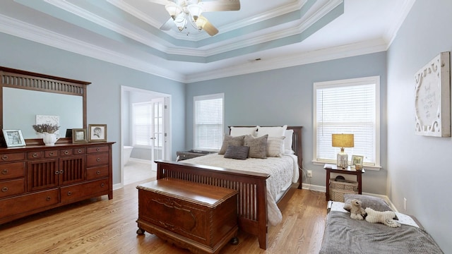 bedroom with a raised ceiling, crown molding, ceiling fan, and light wood-type flooring