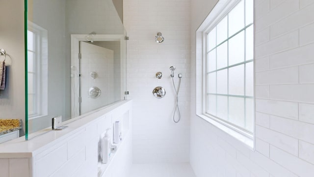 bathroom with tiled shower and a wealth of natural light