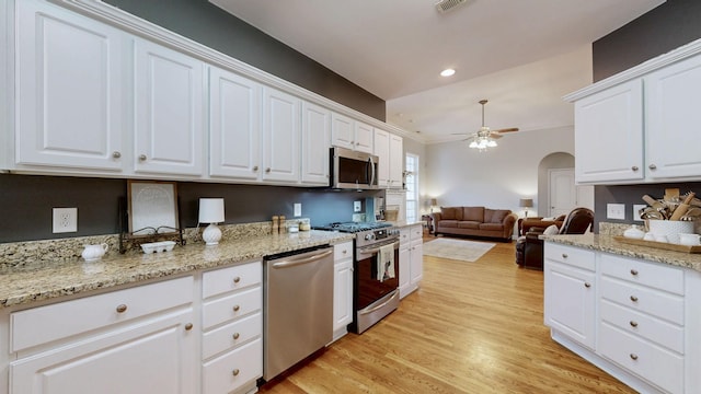 kitchen with stainless steel appliances, light wood-type flooring, white cabinets, and ceiling fan