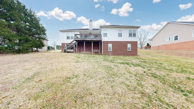 rear view of house featuring a yard and a deck