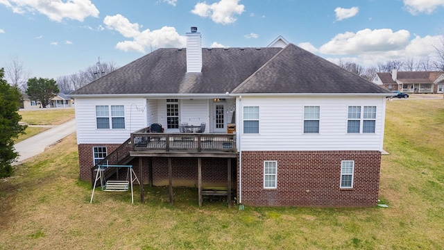 rear view of house with a wooden deck and a yard