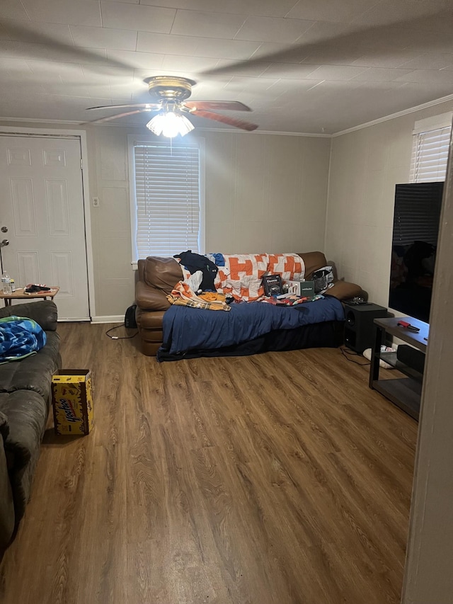 bedroom featuring crown molding, wood-type flooring, and ceiling fan