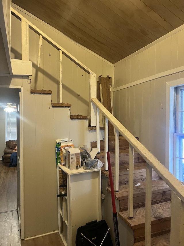 stairs featuring hardwood / wood-style floors and wooden ceiling