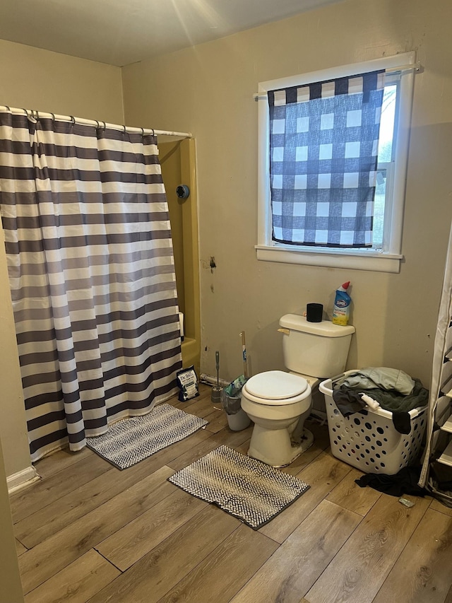 bathroom with wood-type flooring, toilet, and walk in shower