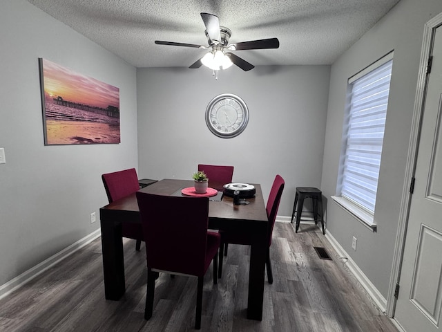 dining area featuring dark hardwood / wood-style flooring, a textured ceiling, and a healthy amount of sunlight