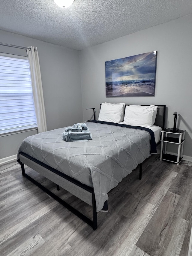 bedroom featuring hardwood / wood-style floors and a textured ceiling