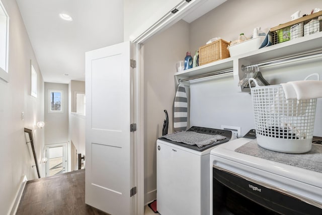 laundry room with washing machine and dryer and dark wood-type flooring